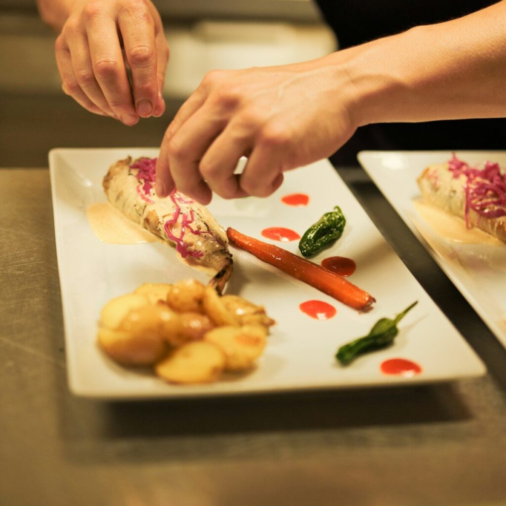 A person is cutting up some food on a plate